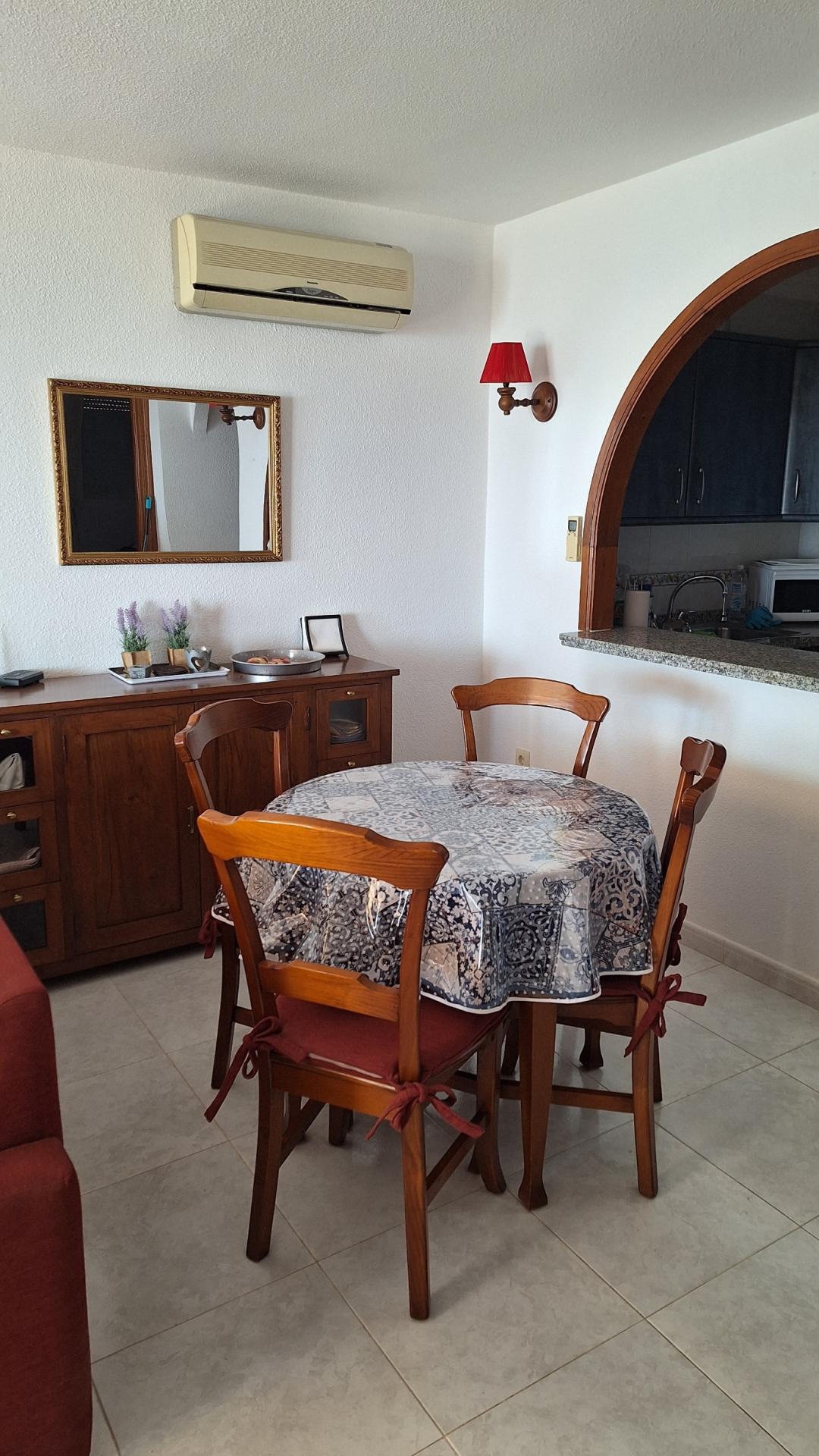 La salle à manger avec passe-plat sur la cuisine ouverte.